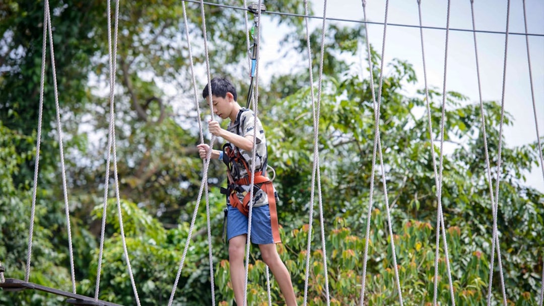 Person navigating a rope course at Mega Adventure Park, Singapore.