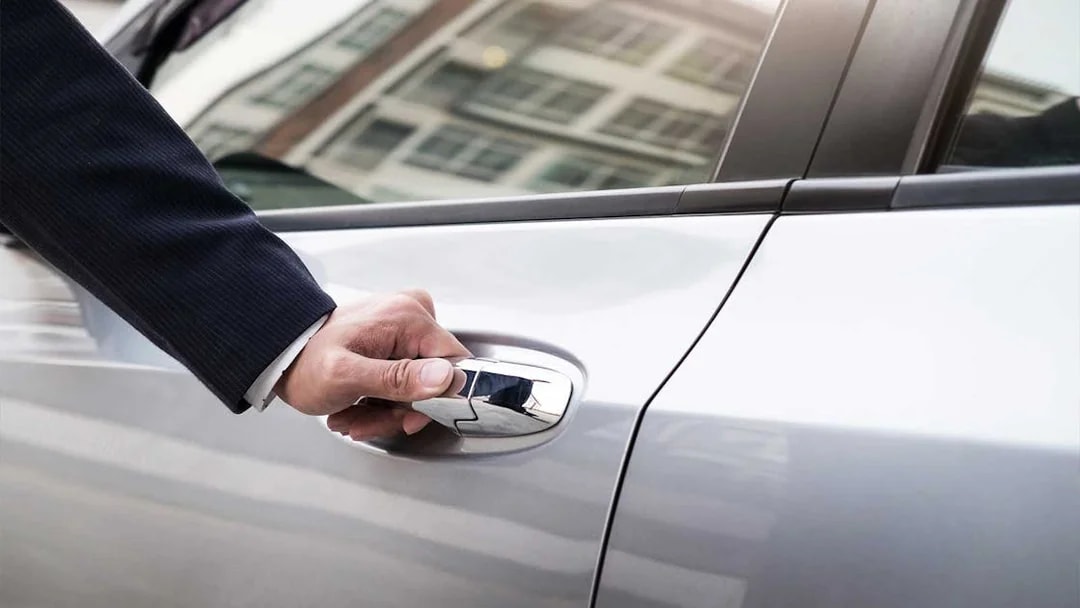 Hand opening car door for shuttle service between Monreale and Palermo.