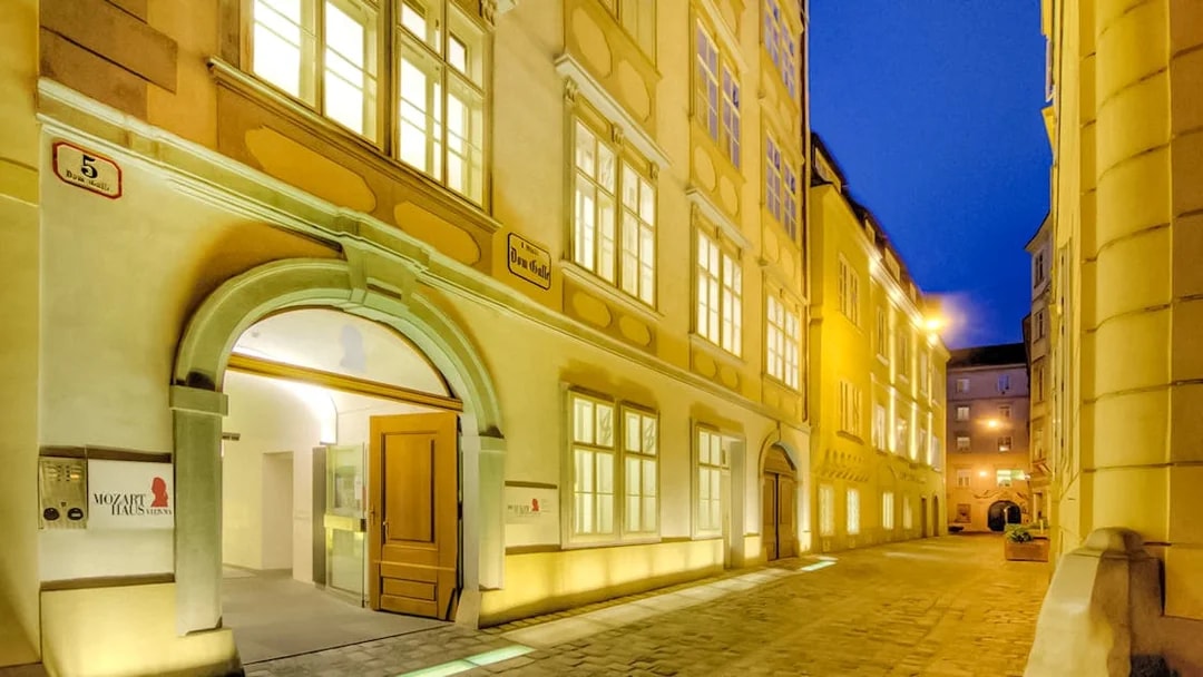 Exterior of Mozarthaus Vienna at night with illuminated windows.