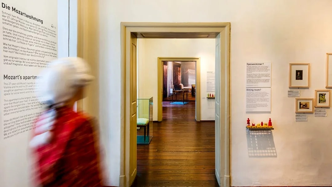 Guests walking through Mozarthaus Vienna exhibit rooms.