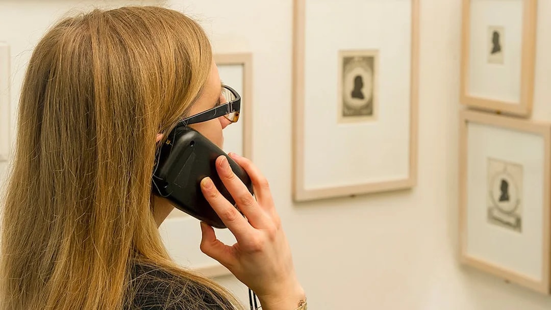 Visitor using an audio guide at Mozarthaus Vienna exhibition.