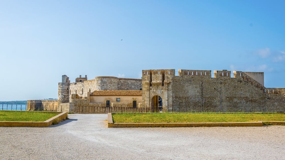 Maniace Castle entrance with stone walls and courtyard in Syracuse, Italy.