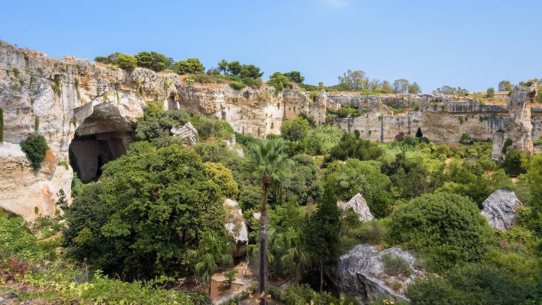 Neapolis Archaeological Park, lush greenery and ancient rock formations, Syracuse.