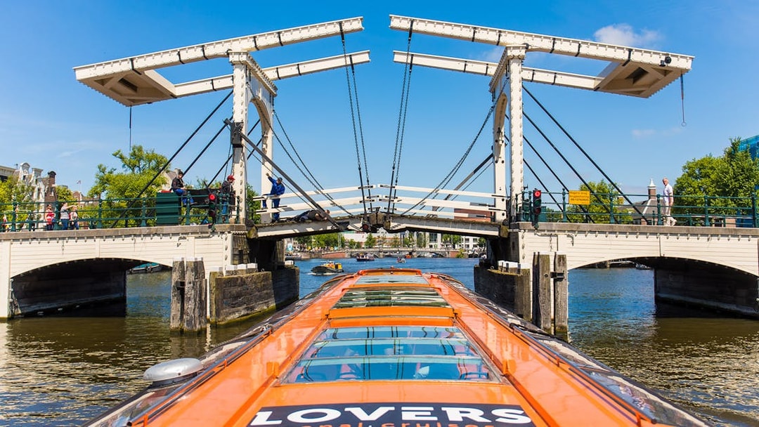 Amsterdam canal cruise boat approaching Magere Brug bridge.
