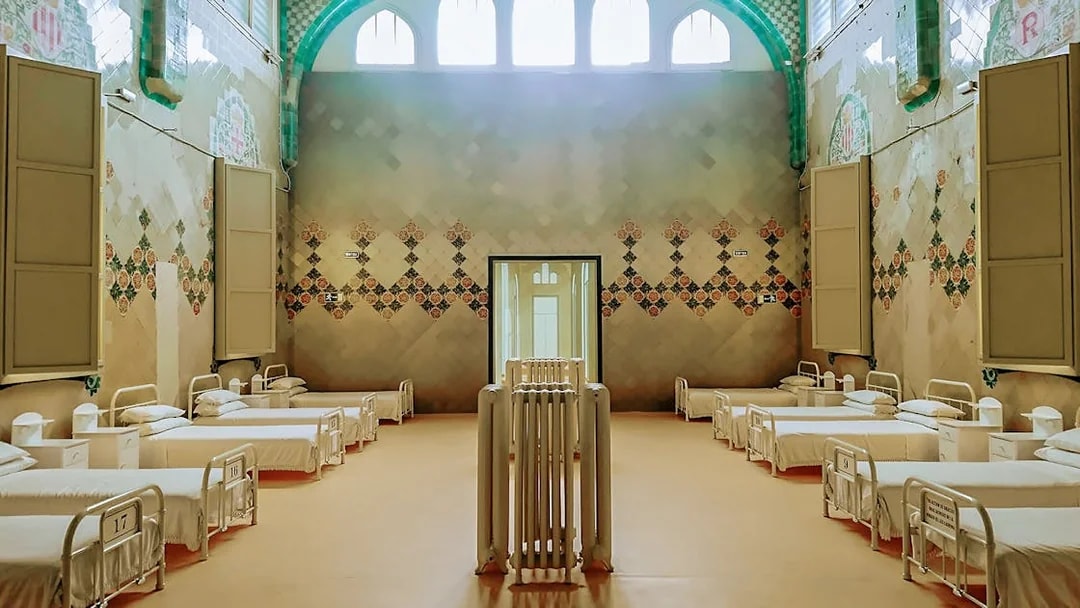 Hospital ward interior at Sant Pau Art Nouveau site, Barcelona, featuring ornate tile designs.
