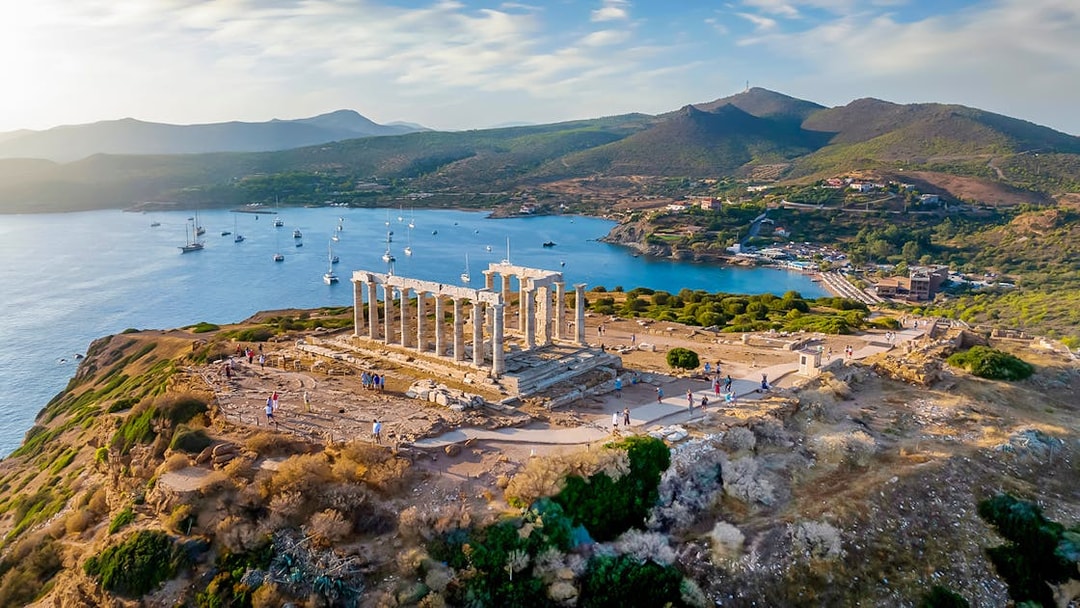 Temple of Poseidon at Cape Sounion overlooking the sea during sunset.