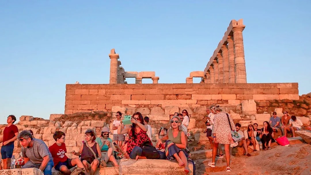 Visitors at Cape Sounion enjoying the sunset near the Temple of Poseidon.