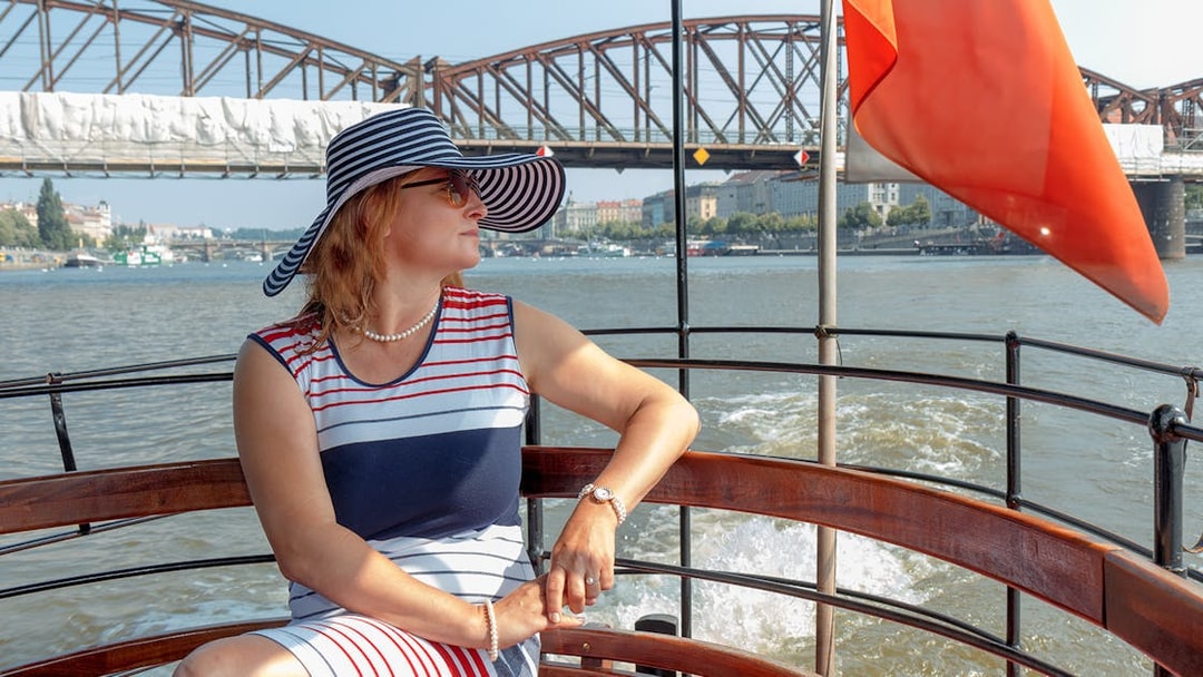 Woman enjoying a cruise on the Vltava River with Prague Castle in the background.
