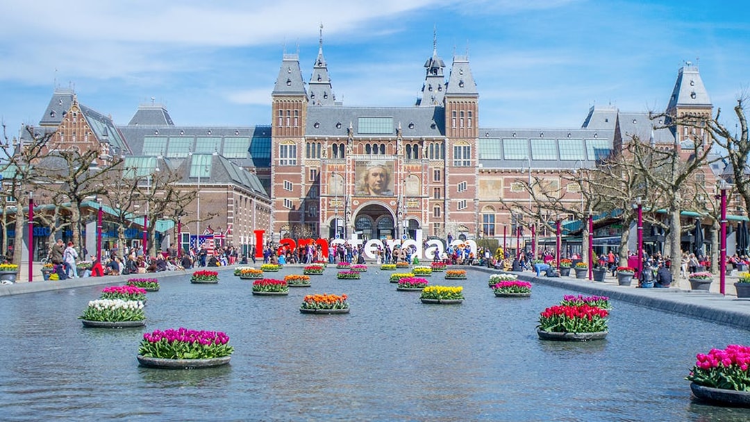 Rijksmuseum Amsterdam with tulip garden and reflecting pool.
