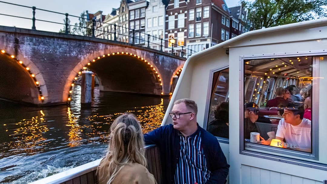 Guests enjoying the Happy Valentine Evening Cruise on Amsterdam's illuminated canal.