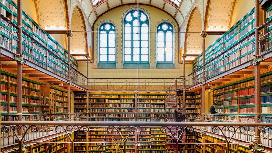 Rijksmuseum library interior with spiral staircase and bookshelves, Amsterdam.