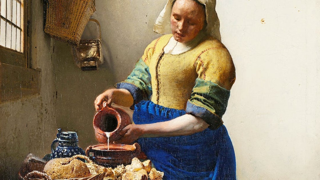 Milkmaid pouring milk into a bowl beside bread and pottery in a rustic kitchen.