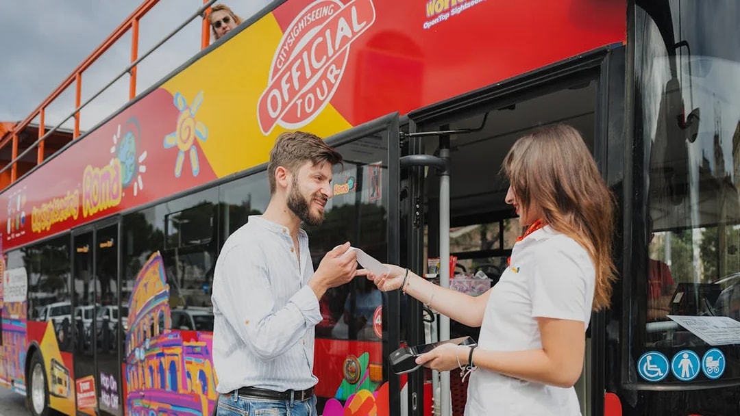 Passenger boarding City Sightseeing bus in Rome, receiving ticket from tour guide.