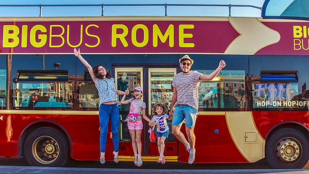 Family jumping in front of Big Bus Rome, excited for city tour.