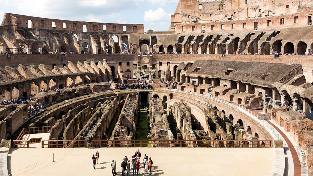 Colosseum arena floor with tourists on a semi-private tour, Rome.