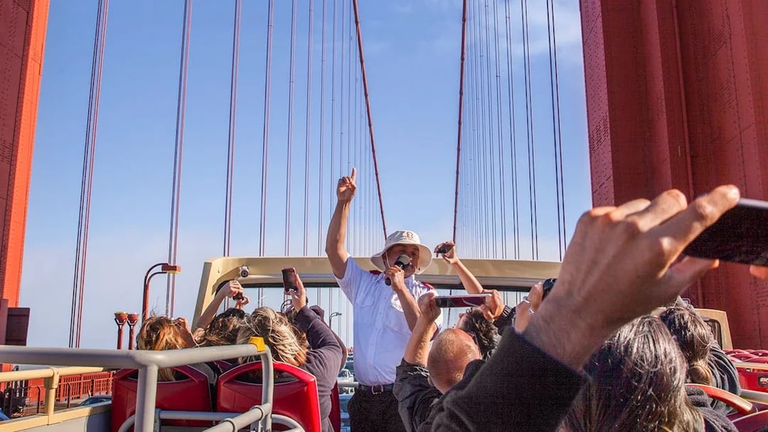 Open-top bus tour crossing Golden Gate Bridge with live guide in San Francisco.