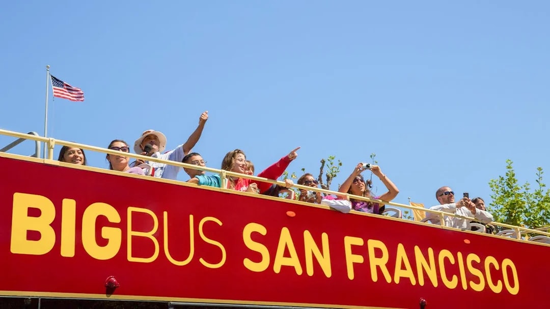 Tourists on San Francisco Big Bus tour with Alcatraz view.