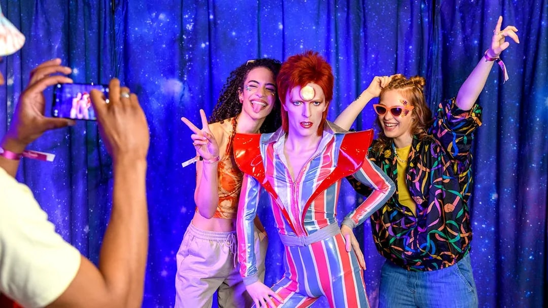 Visitors posing with a wax figure at Madame Tussauds, London.