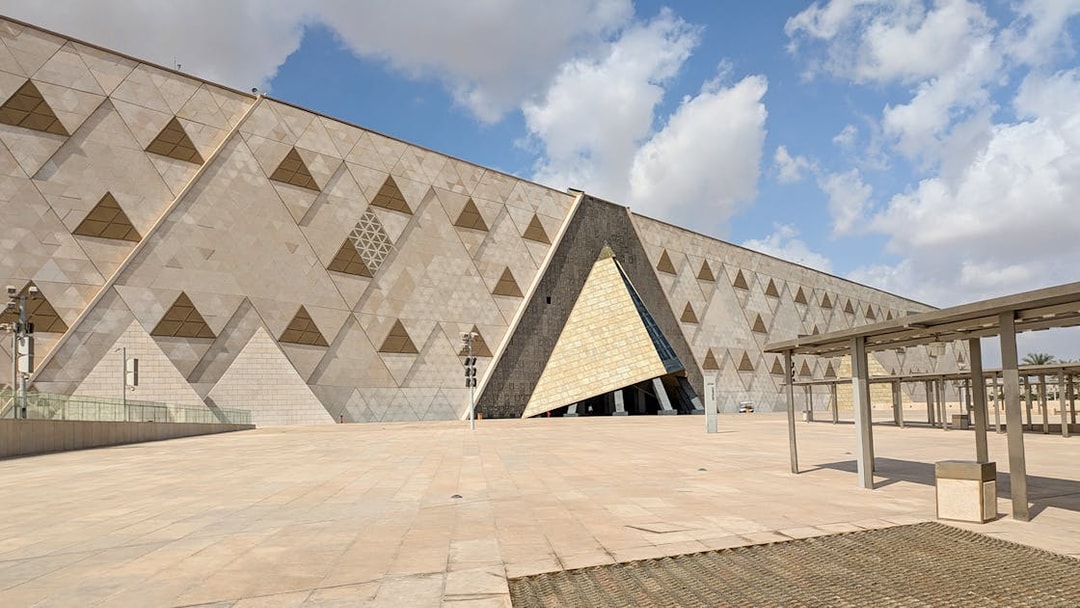 Grand Egyptian Museum facade with geometric patterns under a blue sky.
