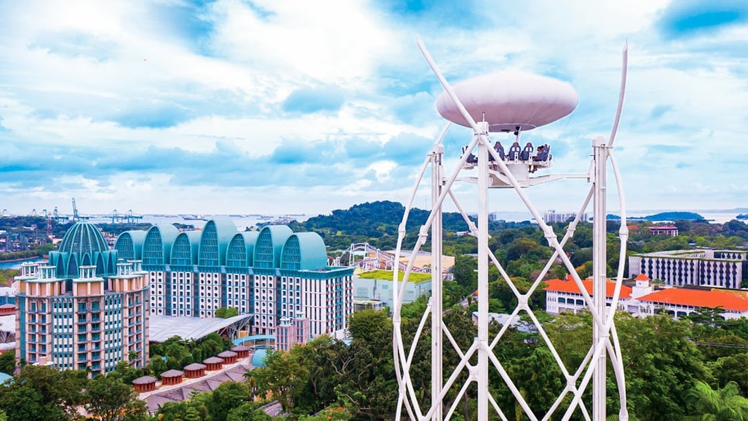 SkyHelix Sentosa ride with panoramic view of Singapore skyline and lush greenery.