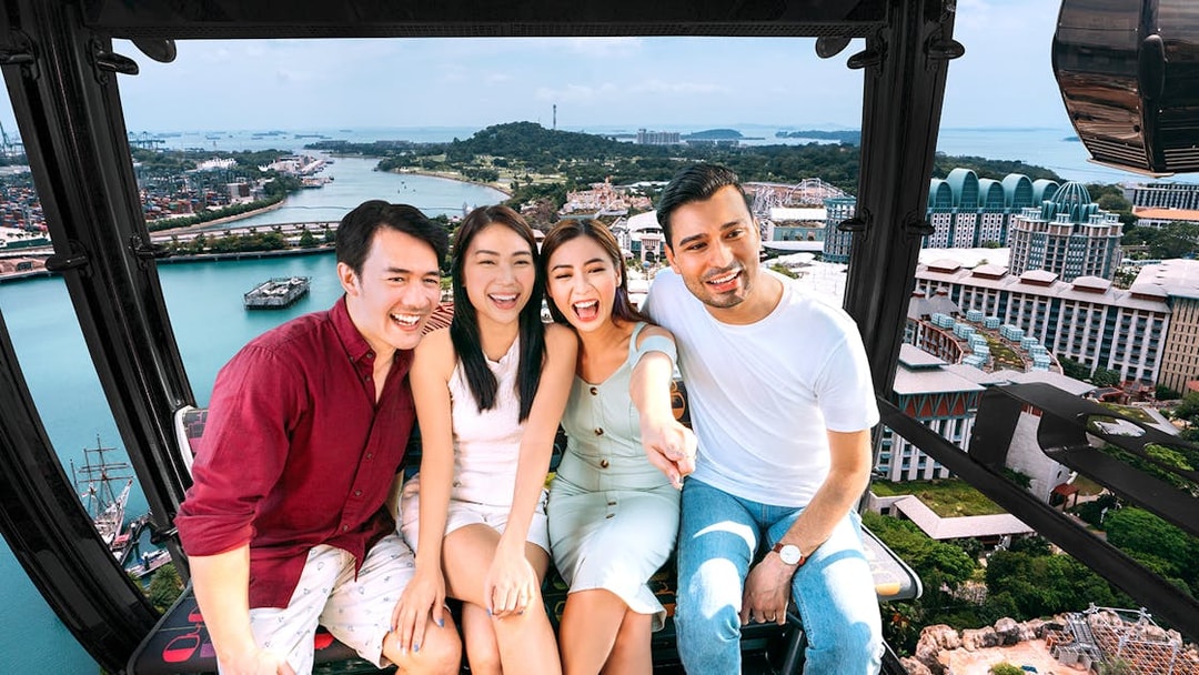 Group enjoying Singapore Cable Car ride with Sentosa Island view.