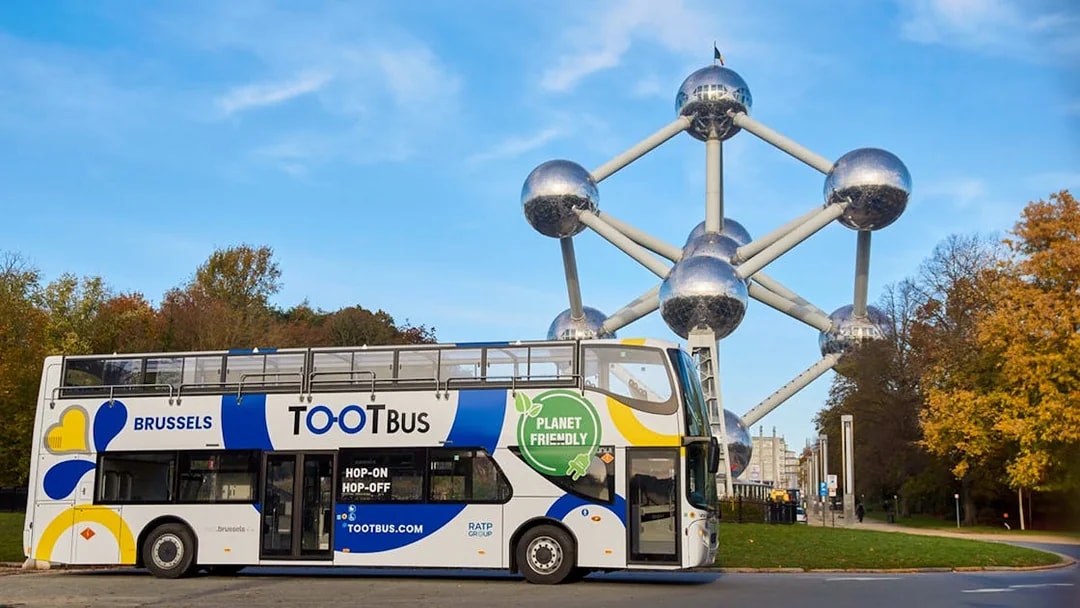 Brussels hop-on hop-off bus near Atomium landmark.