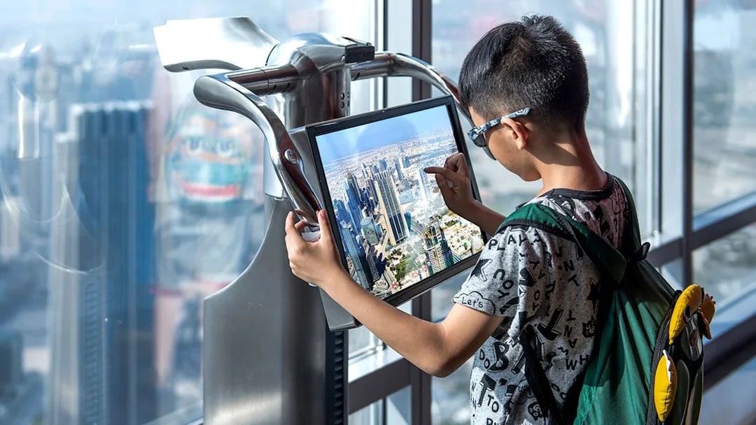 Visitor using interactive screen at Burj Khalifa observation deck, Dubai.