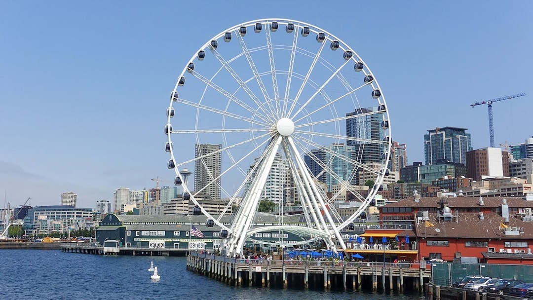 Seattle Great Wheel on waterfront with city skyline in background.