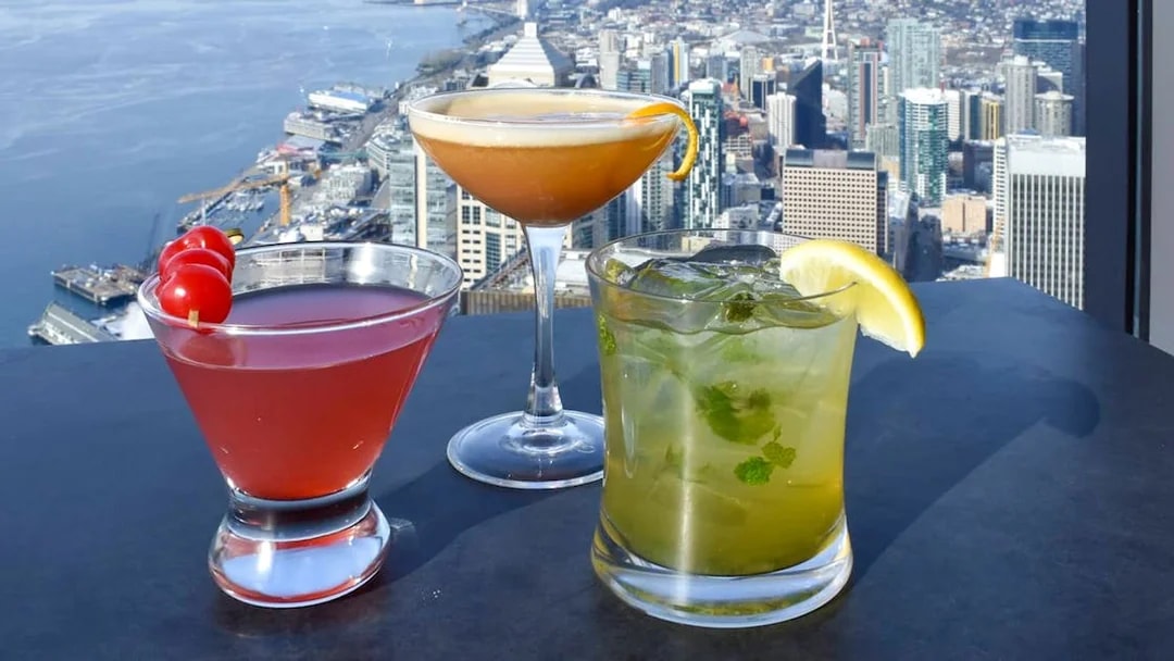 Cocktails on a table with a view of Seattle skyline from Sky View Cafe.