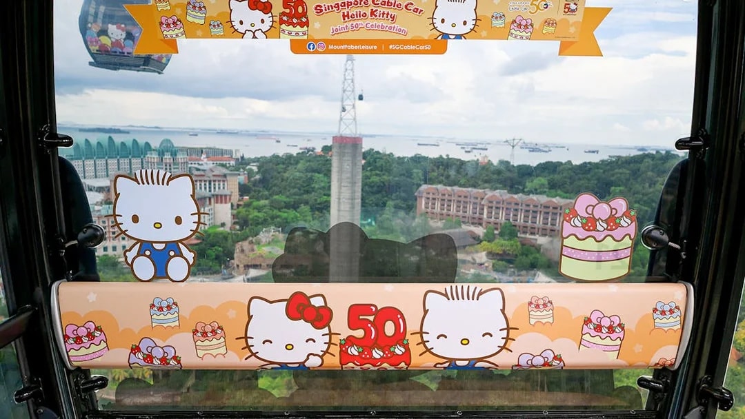 Singapore Cable Car interior with Hello Kitty theme, view of Sentosa Island in background.