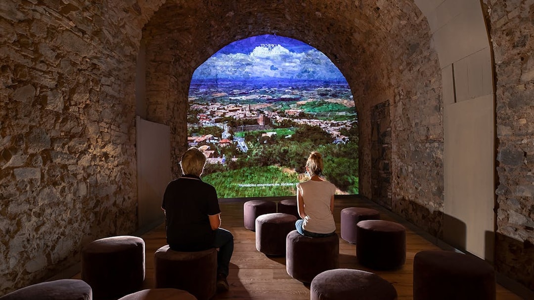 Visitors viewing a projection of Montalcino landscape at Museum of Brunello di Montalcino.
