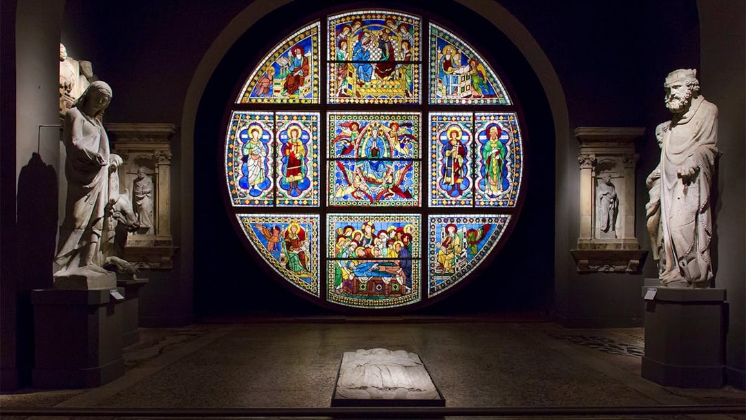 Stained glass window and statues inside Museo dell'Opera Siena