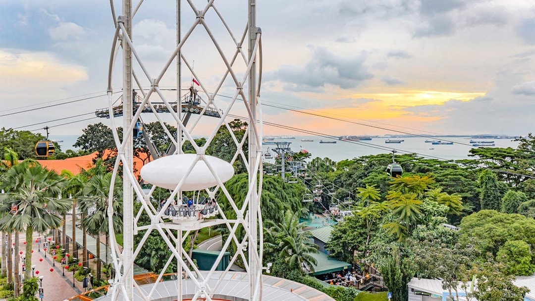 SkyHelix Sentosa ride with panoramic view of Singapore skyline and cable cars.