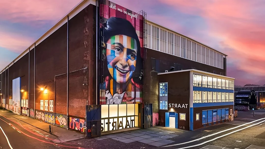 STRAAT Museum exterior with vibrant mural at sunset, Amsterdam.