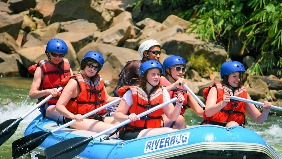 White water rafting group navigating Kampar River rapids in Malaysia.