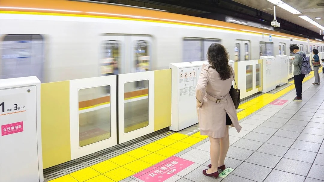 Tokyo subway platform with passengers waiting for a train.