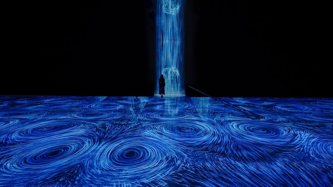 teamLab Planets Tokyo, blue light vortices installation with person standing in the flow.