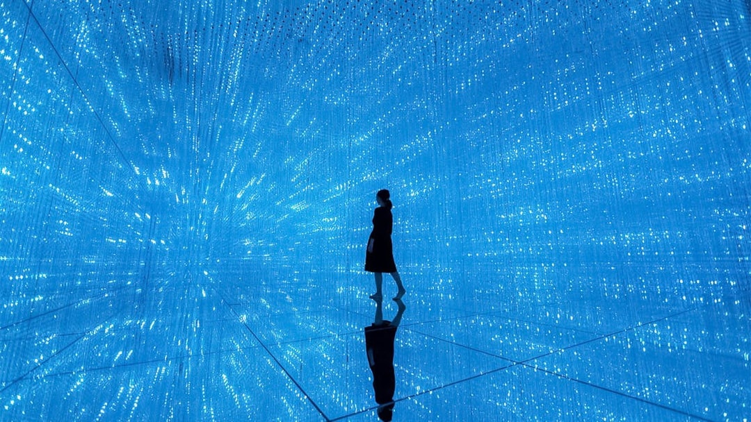 Silhouette in blue digital art installation at TeamLab Planets Tokyo.