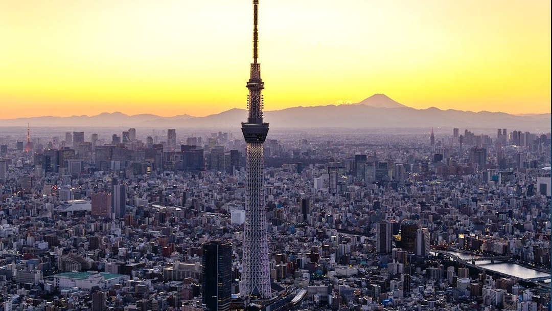 Tokyo Skytree at sunset with cityscape and Mount Fuji in the background.