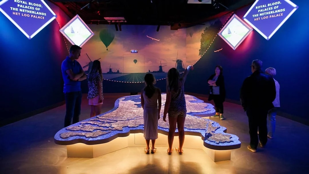 Visitors exploring interactive map at This is Holland exhibit in Amsterdam.