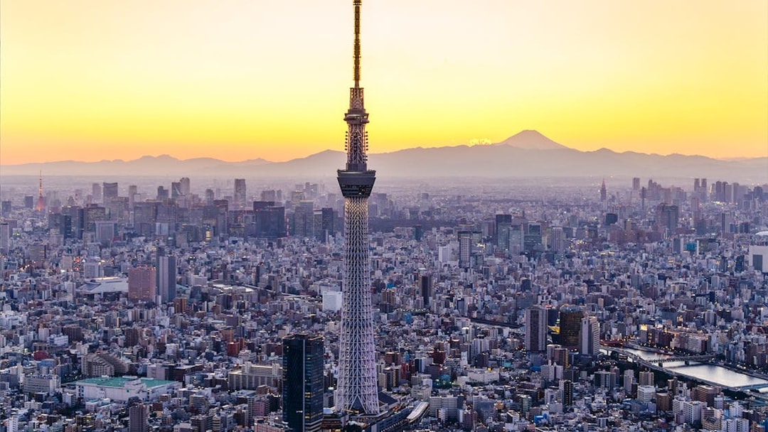 Tokyo Skytree at sunset with cityscape and Mount Fuji in the background.