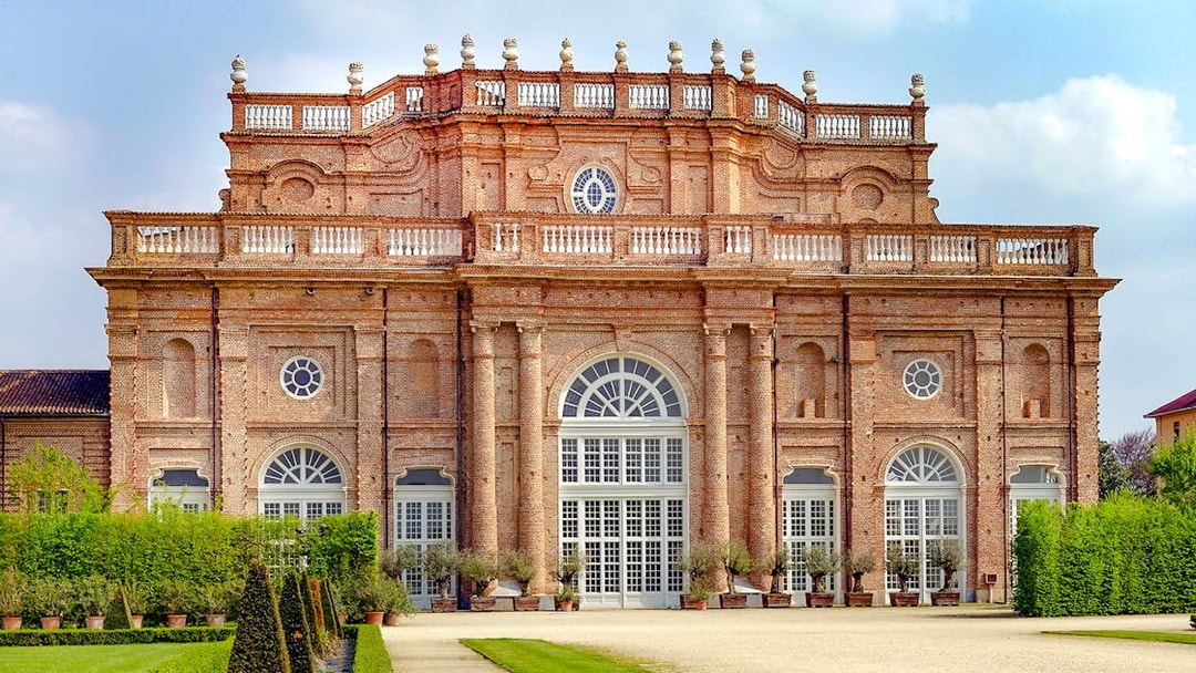 Savoy Royal Residence facade at La Venaria Reale, Turin, with manicured gardens.