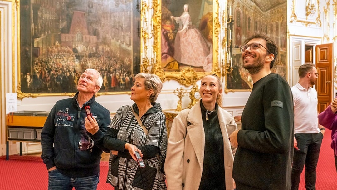 Visitors admiring artwork inside Schonbrunn Palace, Vienna.