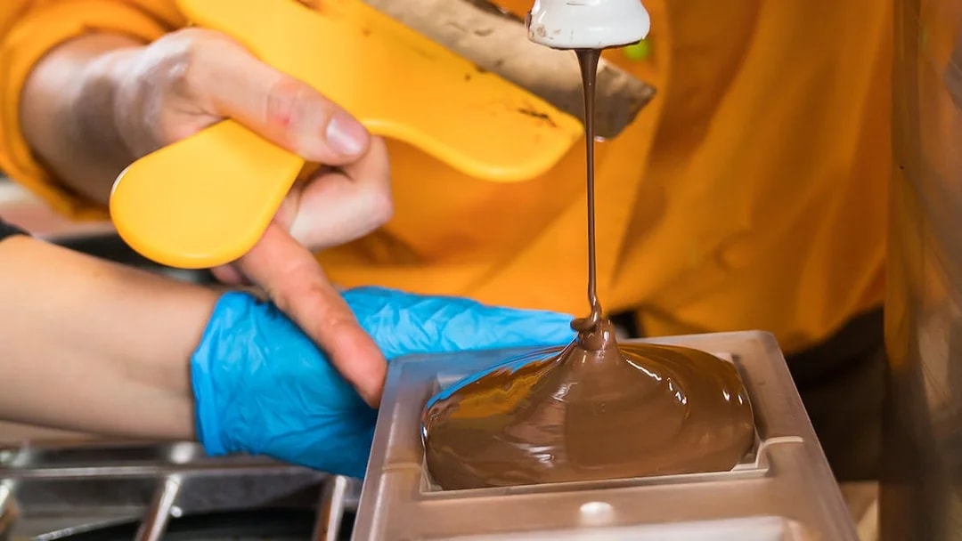 Pouring chocolate into mold during Vienna chocolatier workshop.