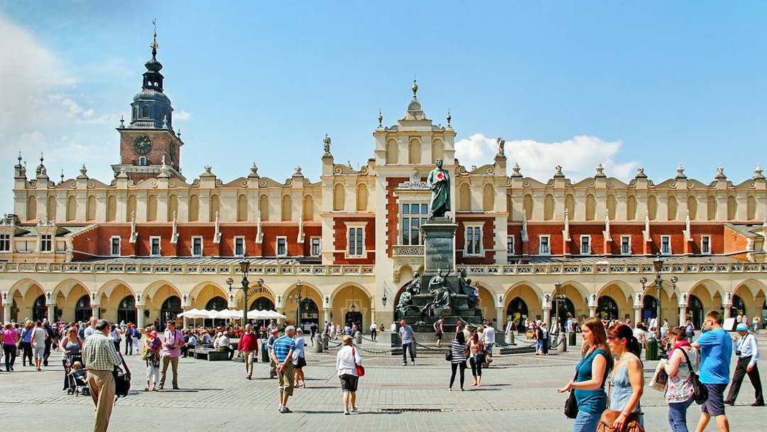Krakow's Cloth Hall in Old Town with people walking nearby.
