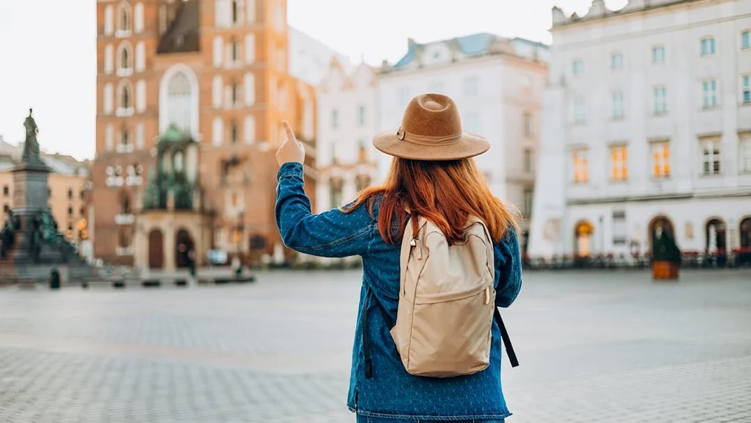 Traveler in Krakow's Old Town pointing at Saint Mary's Basilica.