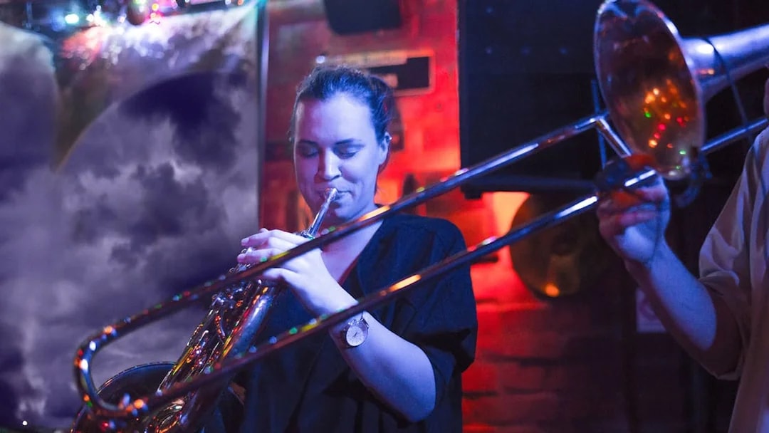 Musician playing trombone at Reduta Jazz Club concert.