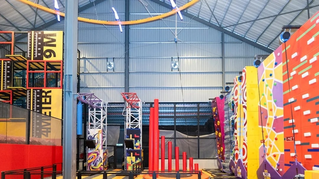 Indoor adventure hub with climbing walls and obstacle course.