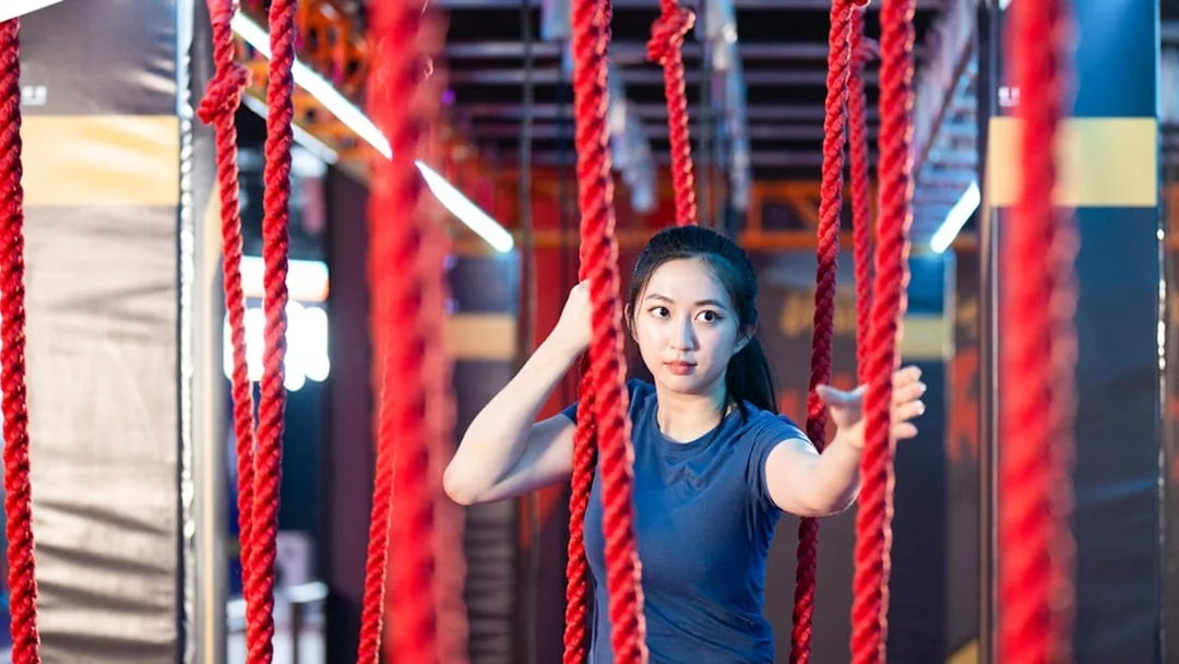 Participant navigating rope course at Conquer Indoor Extreme Park, Monkey Canopy Resort.