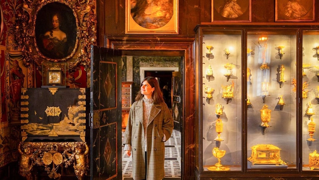 Visitor exploring a historic room with ornate decor and gold artifacts in Copenhagen.